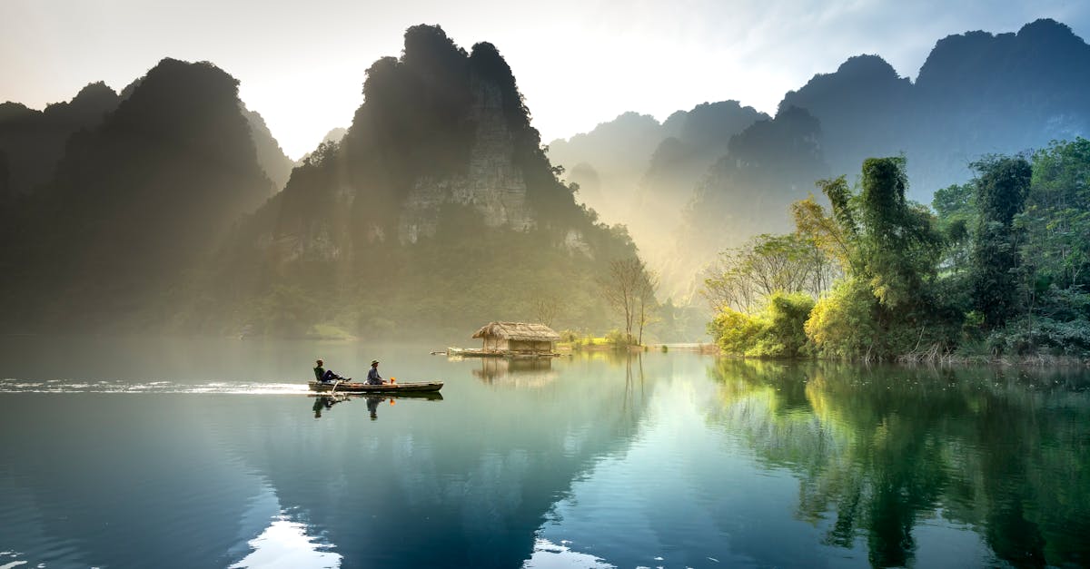 Tranquil lake with mountains reflecting at sunrise in Tuyรชn Quang, Vietnam.