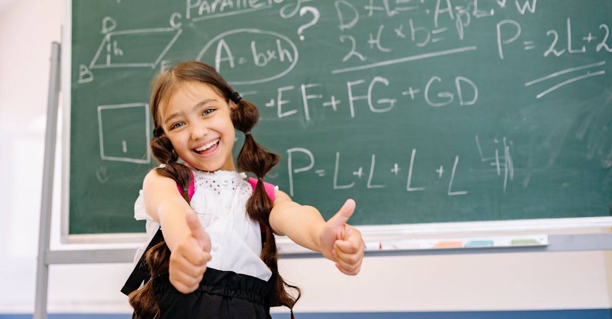Smiling girl giving thumbs up in front of a chalkboard with math equations, wearing a white top.