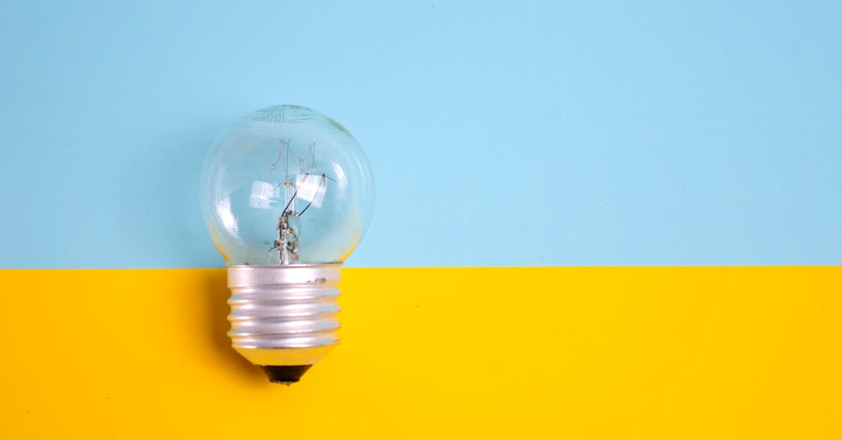 A clear light bulb against a vibrant blue and yellow background, symbolizing energy and creativity.