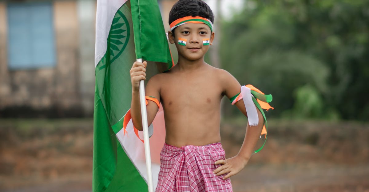 A young boy celebrates Indian Independence Day holding the national flag outdoors in Agartala.
