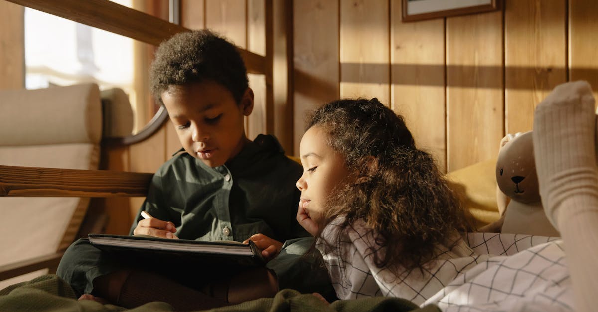 Two children enjoying a reading session together in a warm and cozy room.